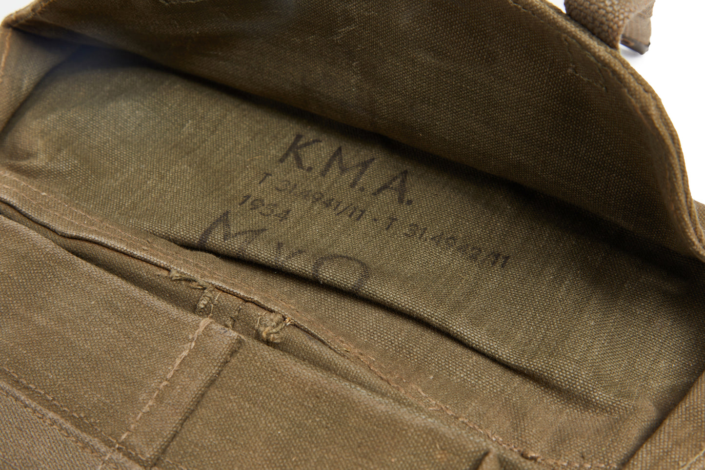 Close-up of a brown bag with 'K.M.A.' and dates markings