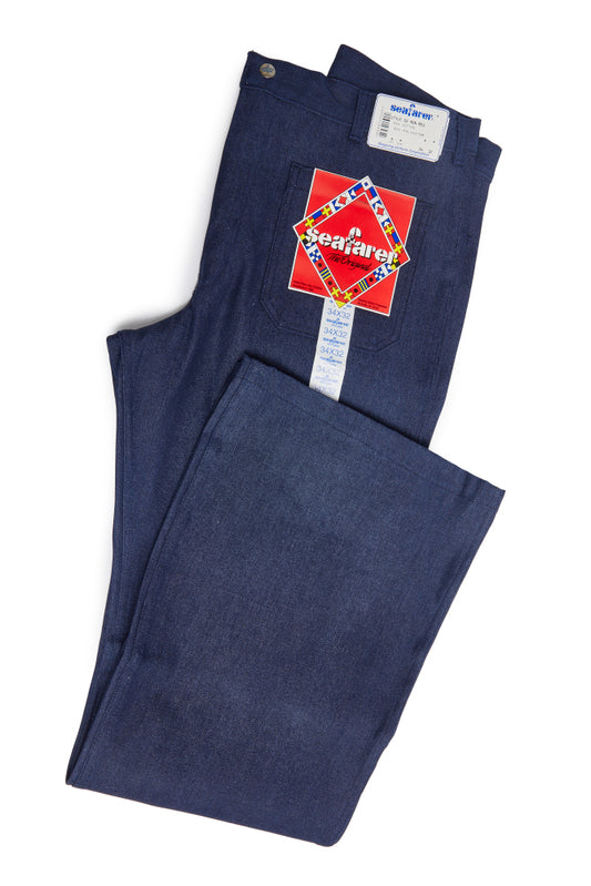 Folded blue jeans with a Seafarer label on a white background