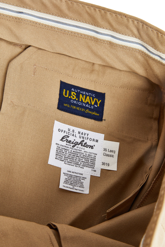 Close-up of khaki pants with U.S. Navy branded labels 