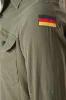 Green military-style uniform with a flag patch on the sleeve.