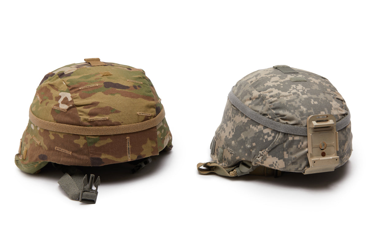 Two camouflage helmets on a white background