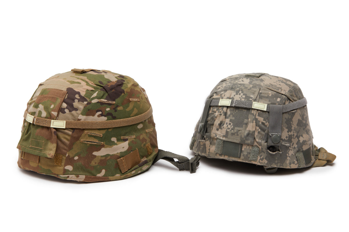 Two camouflage military helmets on a white background