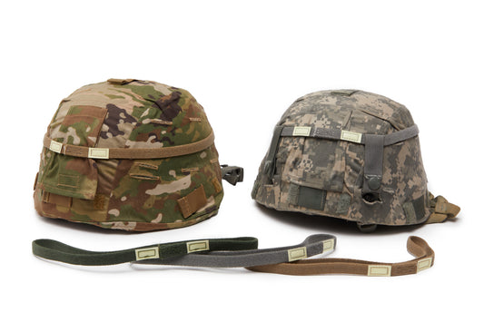 Two camouflage helmets with straps on a white background