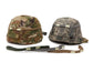 Two camouflage helmets with straps on a white background